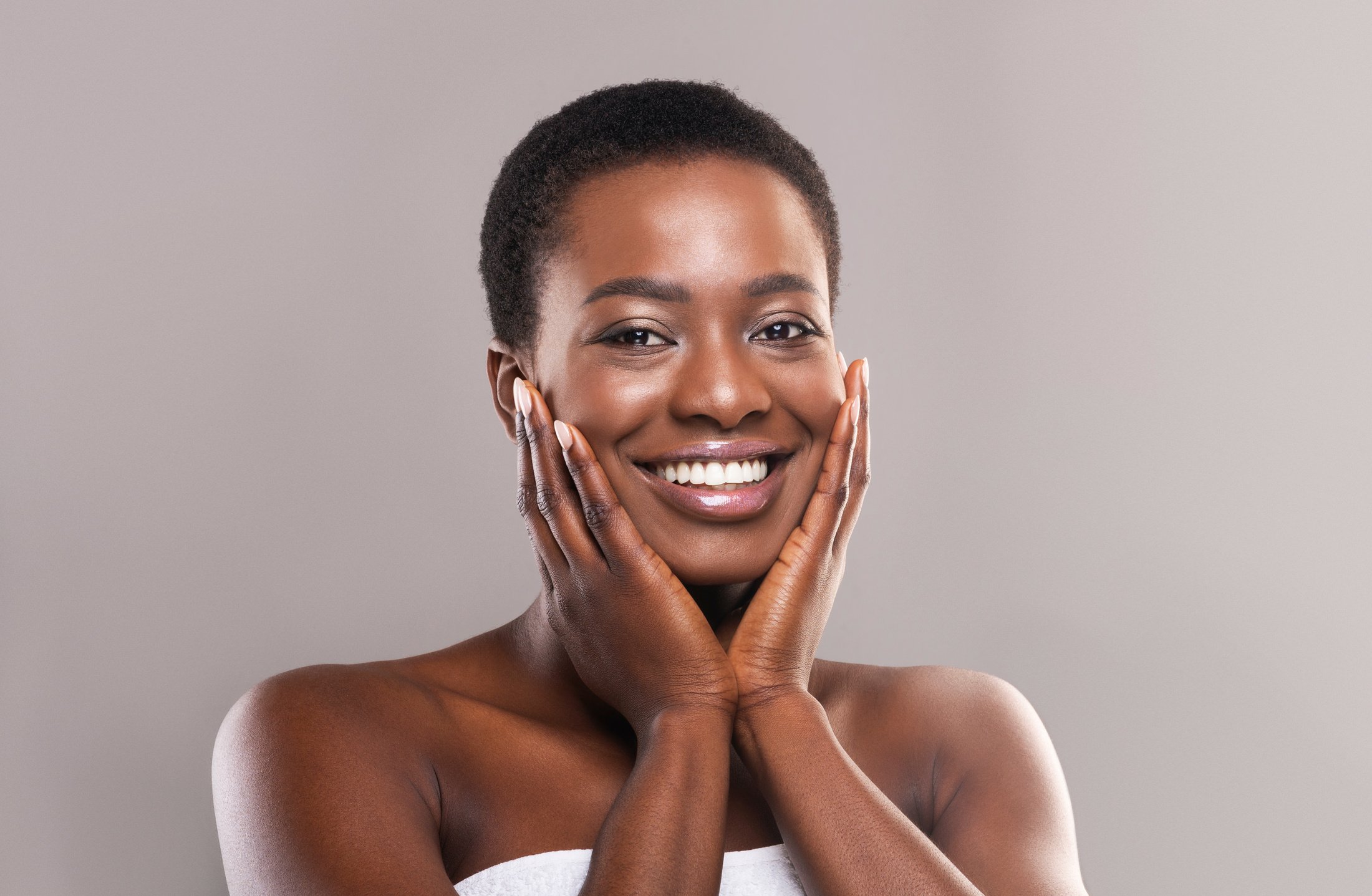 Beautiful black woman touching her face with perfect smooth skin